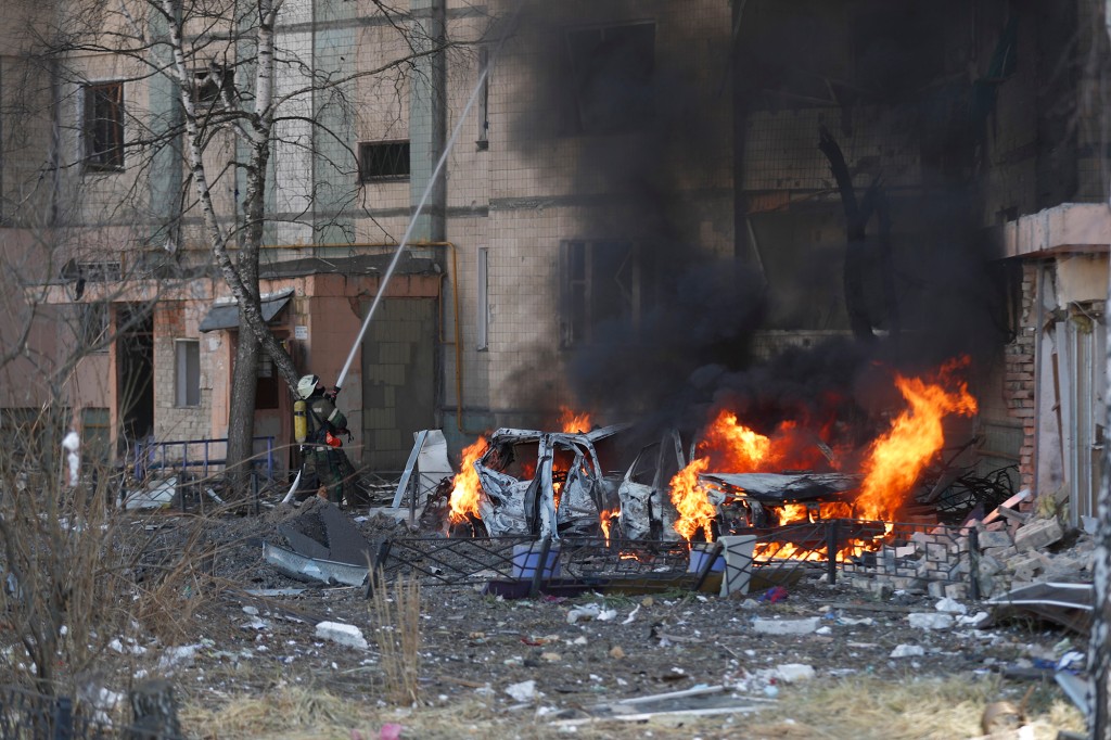 Petugas pemadam kebakaran Ukraina dan tim keamanan di lokasi serangan rudal Rusia di Kyiv.