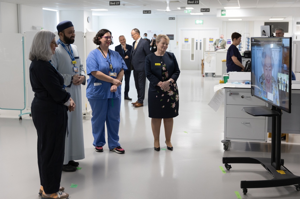 Staf NHS mendengarkan Ratu Elizabeth selama panggilan video untuk memperingati pembukaan unit Ratu Elizabeth di rumah sakit.
