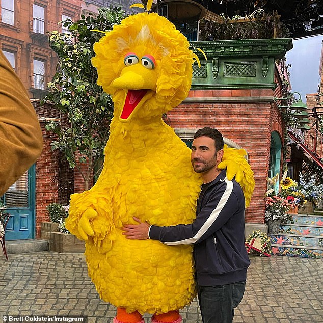 Dia berdiri di samping Big Bird yang terkenal di acara itu saat berada di lokasi syuting serial populer
