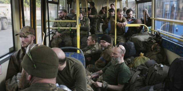 Tentara Ukraina duduk di dalam bus setelah dievakuasi dari pabrik baja Azovstal yang terkepung di Mariupol pada Selasa, 17 Mei. 