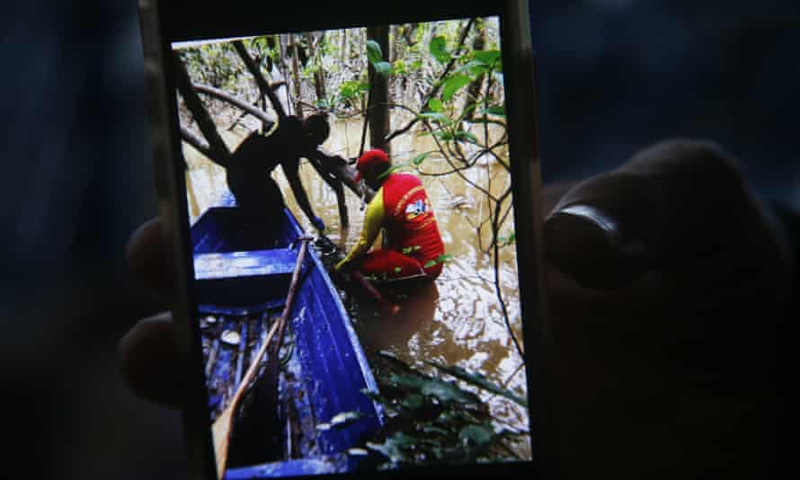 Seorang petugas pemadam kebakaran memegang telepon dengan gambar yang menunjukkan saat ransel ditemukan saat mencari ahli Aborigin Bruno Pereira dan jurnalis Inggris Dom Phillips