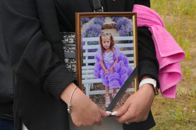 Seorang wanita memegang potret Lisa, seorang gadis berusia 4 tahun yang tewas dalam serangan Rusia, selama upacara pemakaman di Vinnytsia, Ukraina, pada 17 Juli 2022. Lisa termasuk di antara 23 orang yang tewas, termasuk dua 7 dan 8- anak laki-laki berusia tahun, dalam serangan Rocket pada hari Kamis di Vinnytsia.  Ibunya, Irina Dmitrieva, termasuk di antara mereka yang terinfeksi.