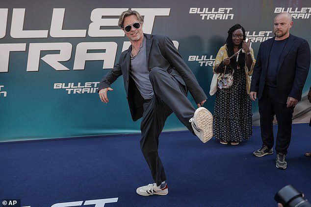 MENANGKAP: Bintang film Brad mengenakan sepasang sepatu kets putih yang nyaman saat dia mengangkat kakinya ke arah fotografer saat dia berjalan di karpet biru