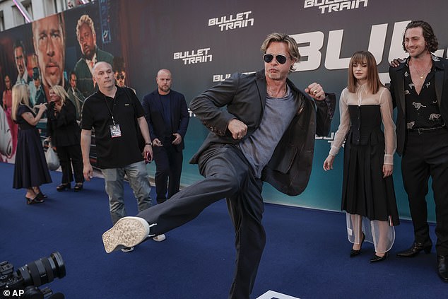 Akting: Brad Pitt, 58, memberikan pertunjukan bersemangat menendang kakinya di udara di pemutaran perdana Kereta Peluru di Paris pada hari Senin