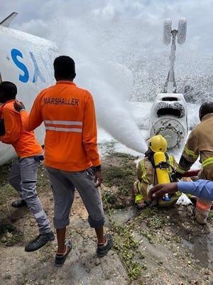 Paramedis Somalia memadamkan api yang menyasar pesawat Juba Air pada Senin, 18 Juli 2022, di Bandara Internasional Mogadishu, Mogadishu, Somalia.  Tiga tentara dari Brigade Bantuan Keamanan ke-2 dari Fort Bragg membantu responden pertama merawat 16 penumpang yang terluka.