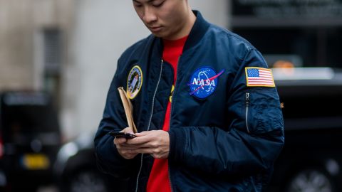 Seorang tamu mengenakan jaket bomber NASA selama koleksi pria di London Fashion Week di Matthew Miller pada 7 Januari 2017 di London, Inggris.