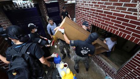 Tentara membawa puing-puing dari sebuah rumah yang terendam banjir di Seoul, Korea Selatan, pada 10 Agustus.