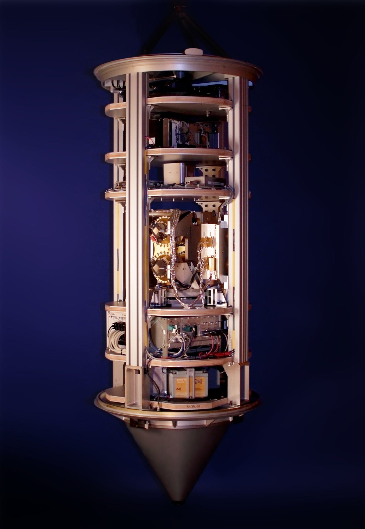 Badan silinder perunggu memegang instrumen ilmiah dengan dasar runcing