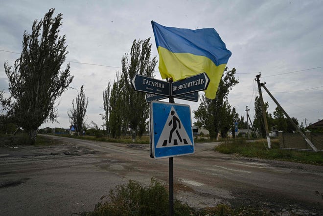 Bendera Ukraina melambai di sebuah jalan di desa Vysokopila yang baru saja dibebaskan, wilayah Kherson, pada 27 September 2022.