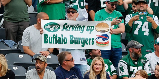 Seorang penggemar New York Jets memegang spanduk Serving up Buffalo Burgers selama kuarter keempat pertandingan National Football League antara New York Jets dan Buffalo Bills pada 6 November 2022 di MetLife Stadium di East Rutherford, New Jersey. 
