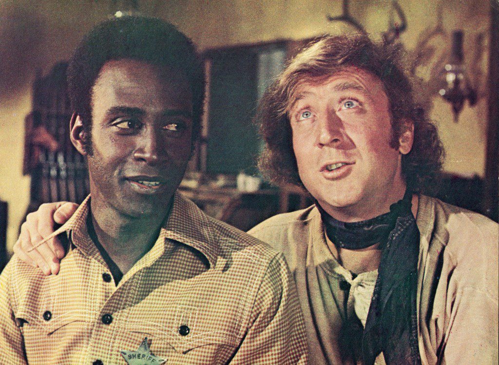 Gene Wilder (kanan) melingkarkan lengannya di bahu Cleavon Little dalam gambar diam dari film, "pelana menyala," Disutradarai oleh Mel Brooks, 1974.