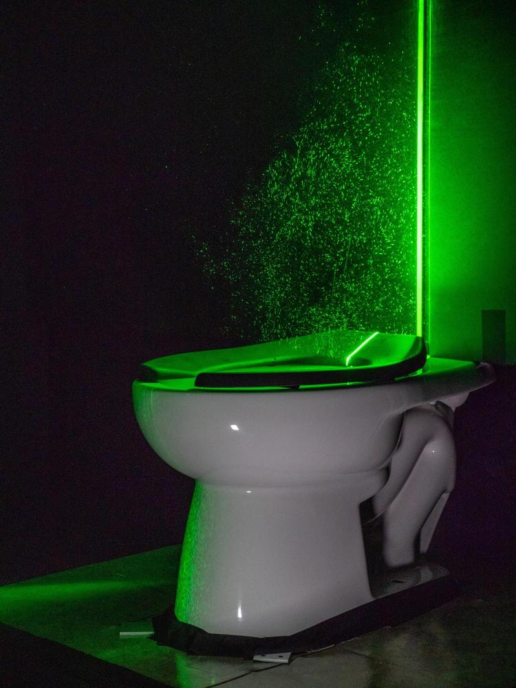 Laser hijau yang kuat membantu memvisualisasikan semburan aerosol dari toilet 